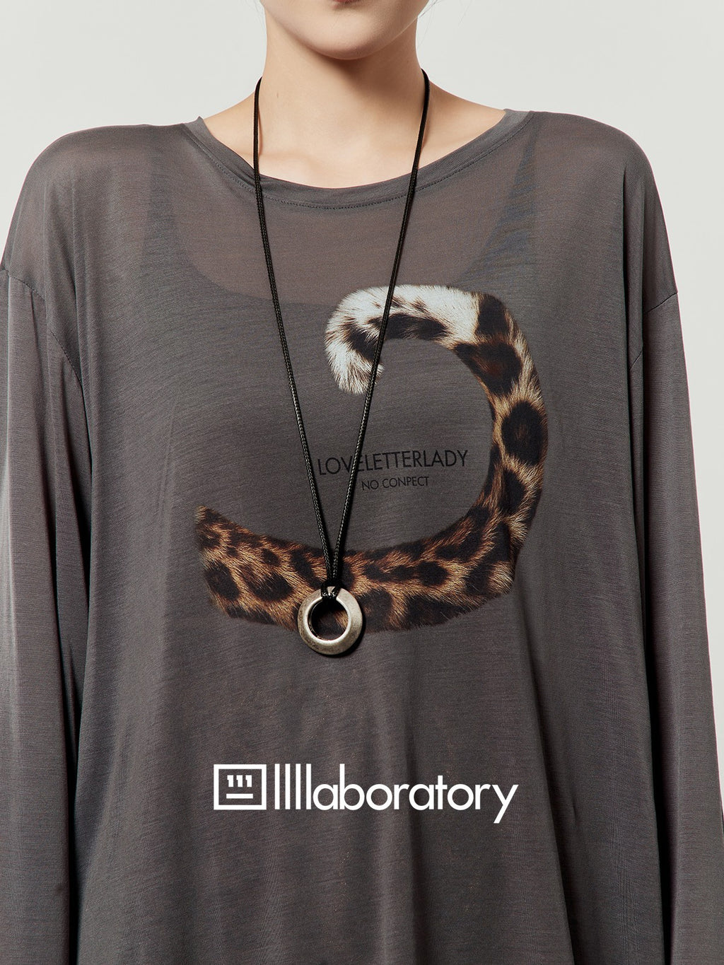 Close detail of wasteland gray long-sleeve top with original leopard-tail artwork
