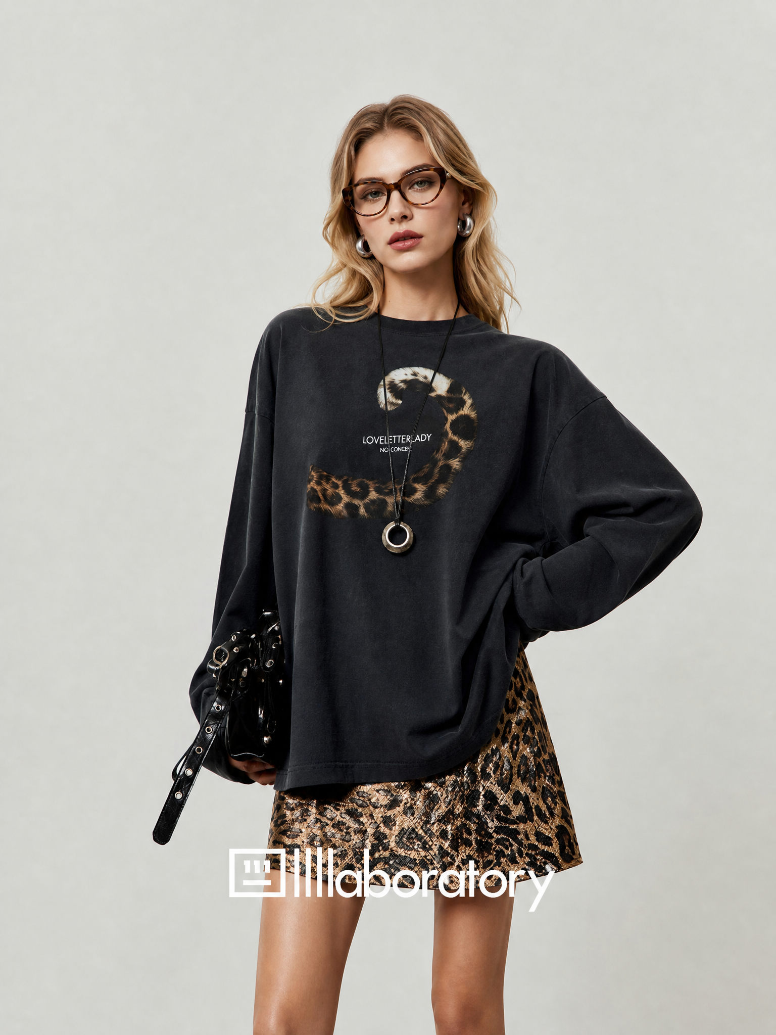 European blonde woman wearing the black leopard-tail long-sleeve graphic top