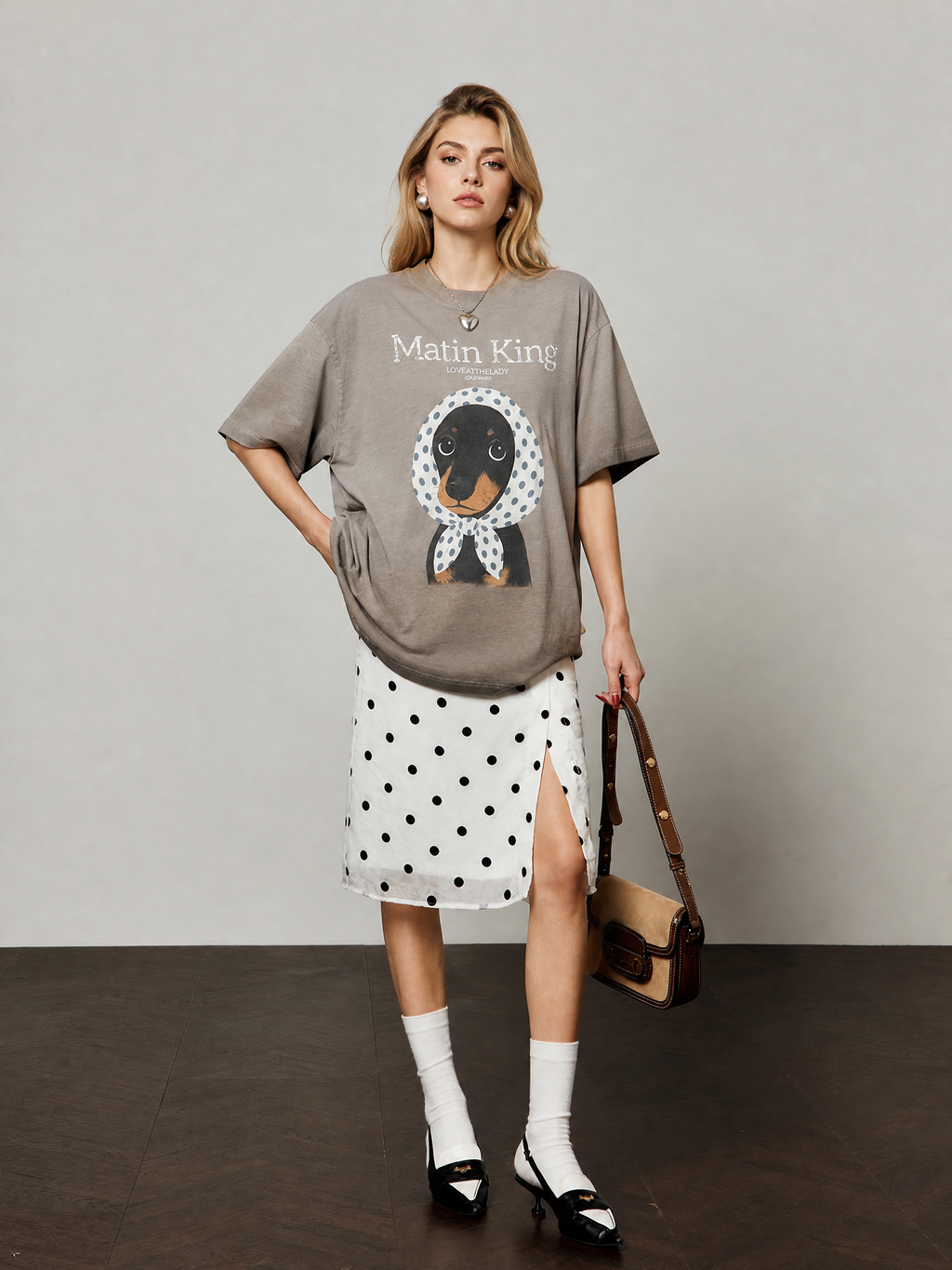 European female model wearing the coffee-brown scarf-pup graphic tee with white flocked skirt