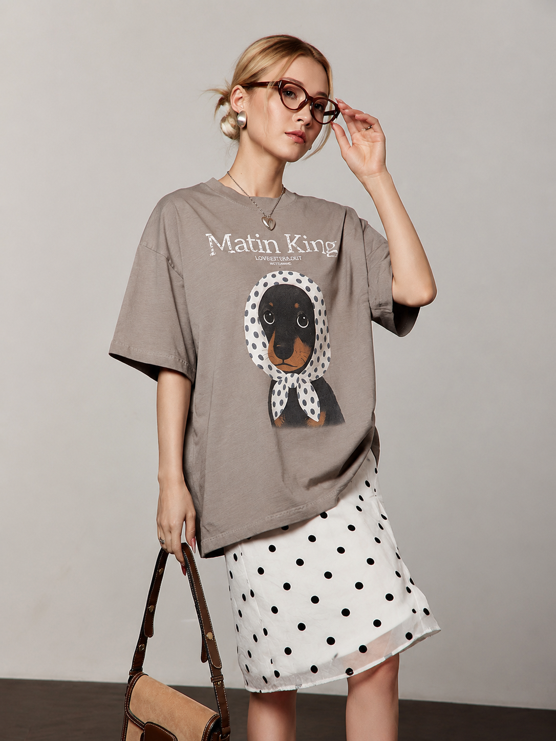 European female model showing the coffee-brown tee and coordinating white polka-dot flocked skirt